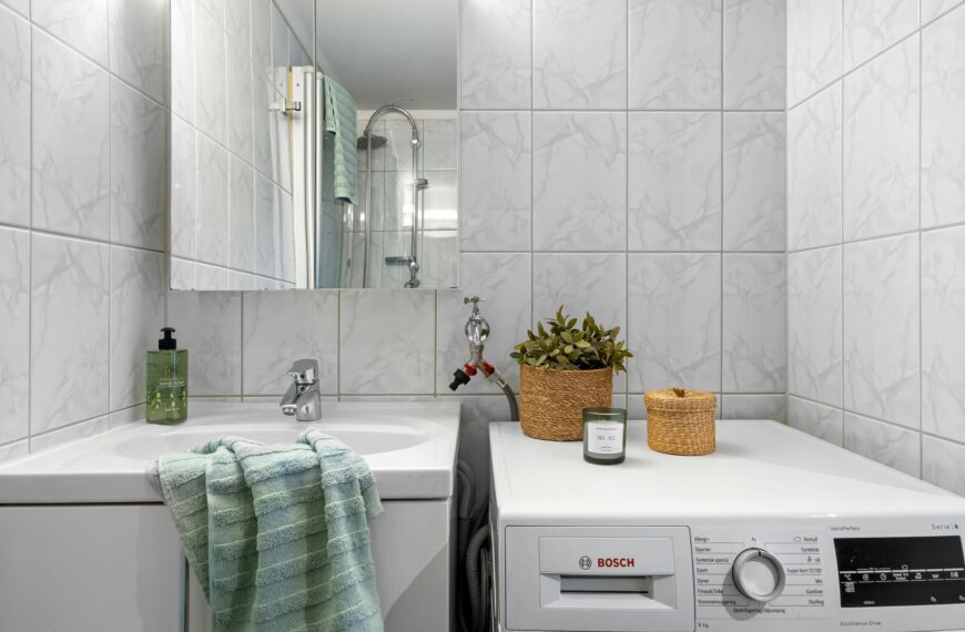 Pralka Bosch ustawiona obok umywalki w łazience